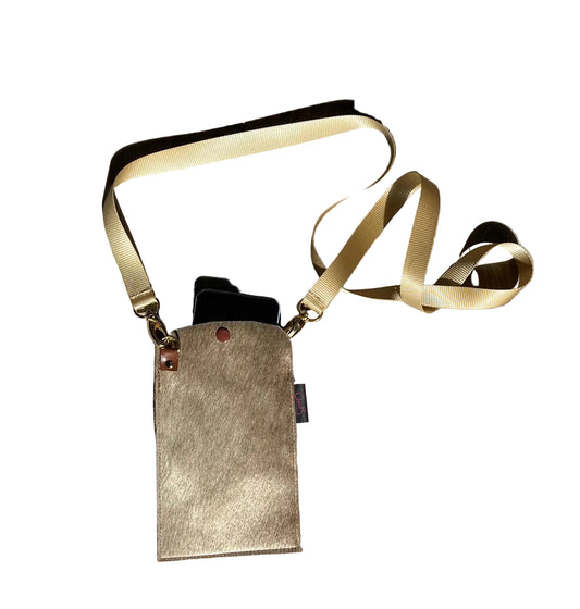 Small leather pouch with gold strap on a wooden surface