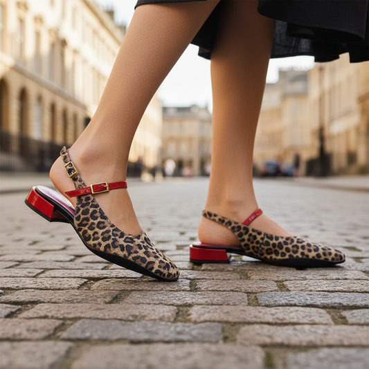 Leopard print shoe with red strap on a light gray background