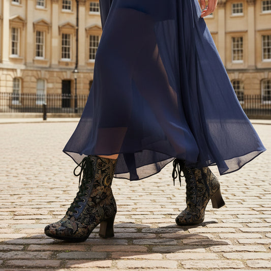 Black lace-up boot with intricate design on a white background