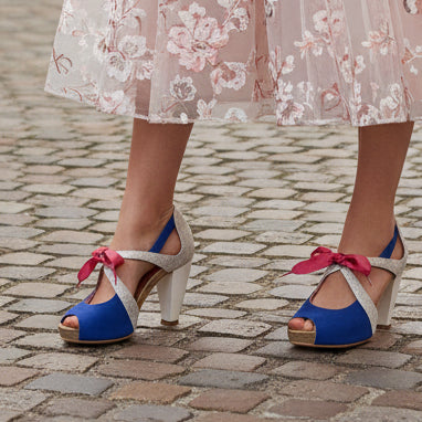 woman on a cobbled street wearing martini blue and silver heels with ribbon lace