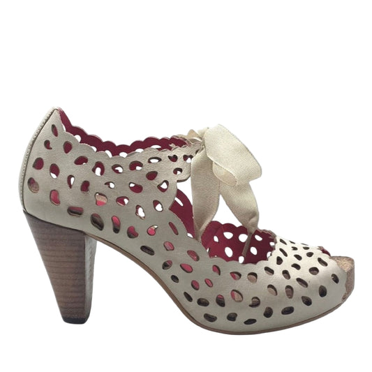 A beige natural lace-up cork peep toe dress sandal with a platform heel and cork footbed, featuring perforated detailing and a bow on the ankle strap.