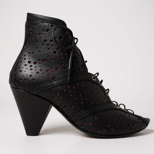 Black perforated high-heeled shoes on a white background