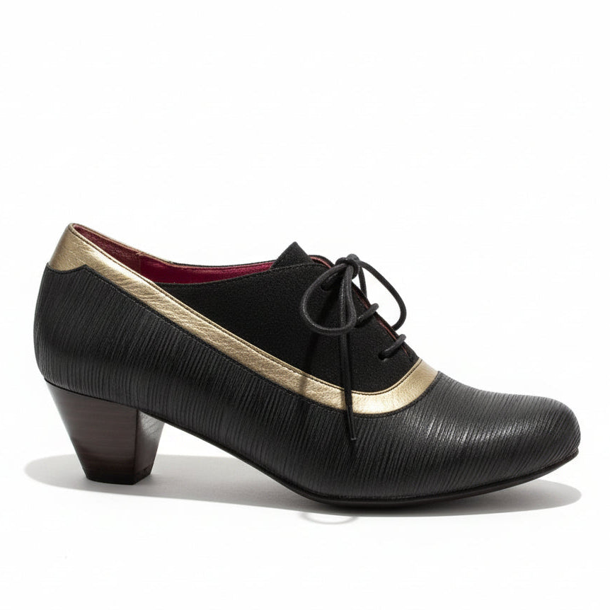 Brown shoe with gold trim on a stone floor