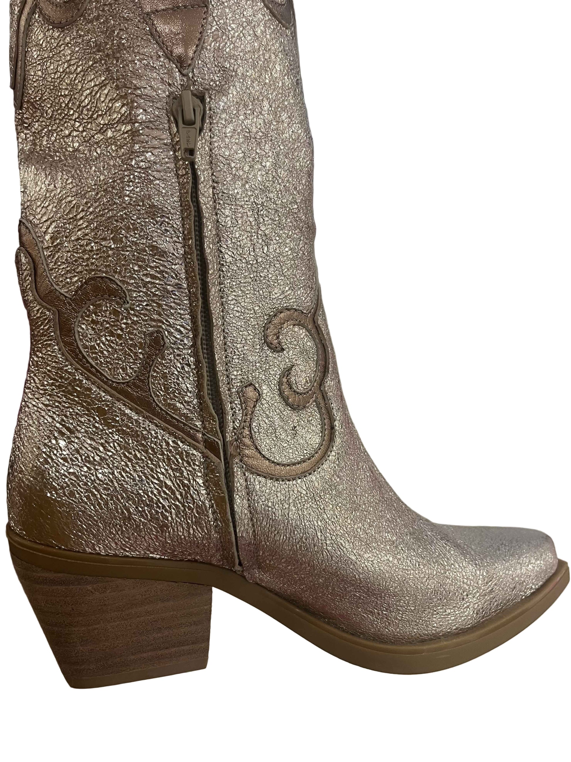 Silver glittery boot with decorative design on a light background