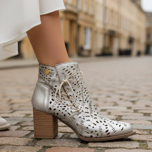 White lace-up boots with a block heel on a cobblestone street.
